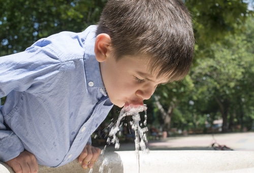 Image of a boy drinking water in a park